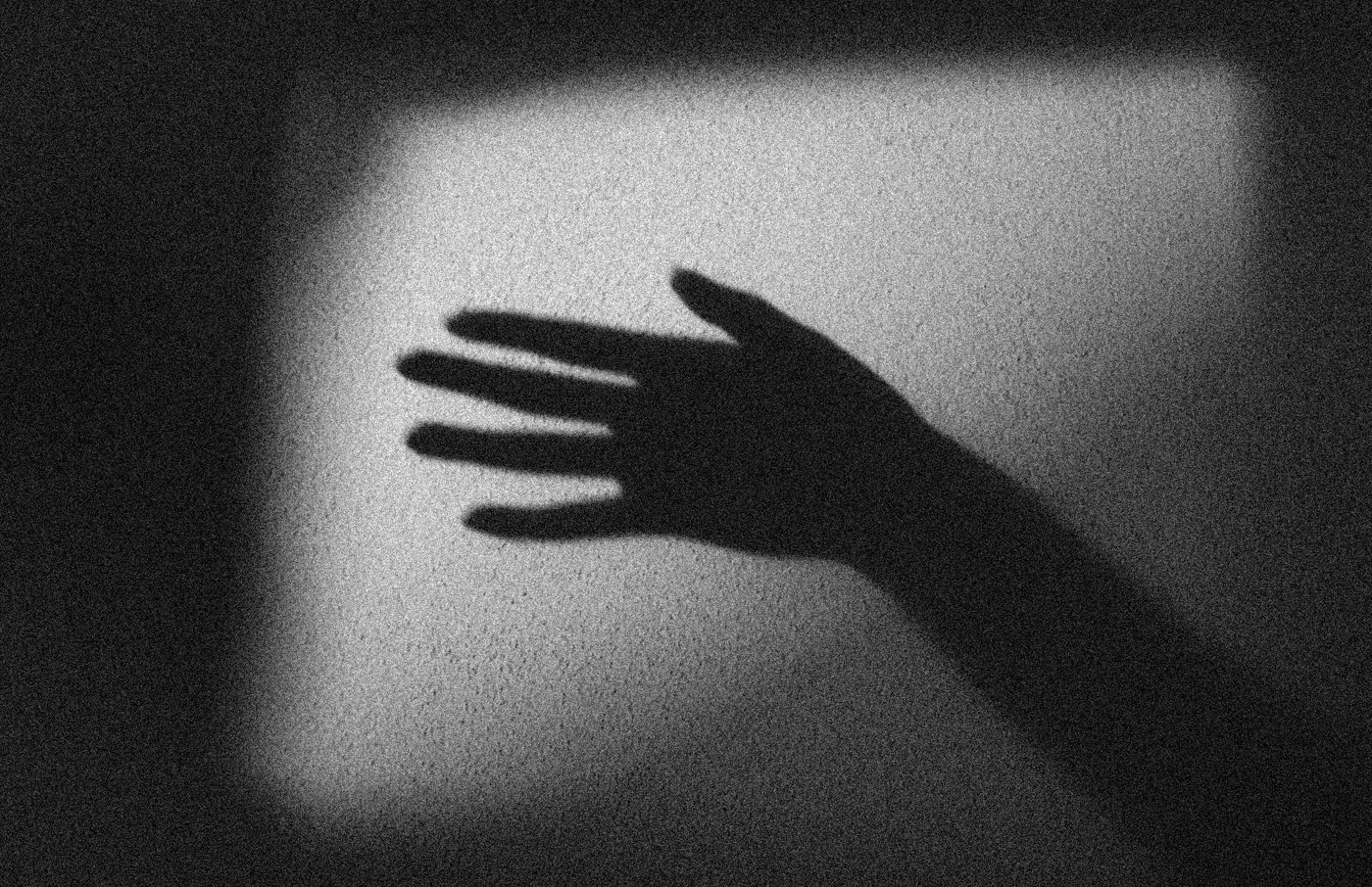 Shadow of a hand against a pale square of light